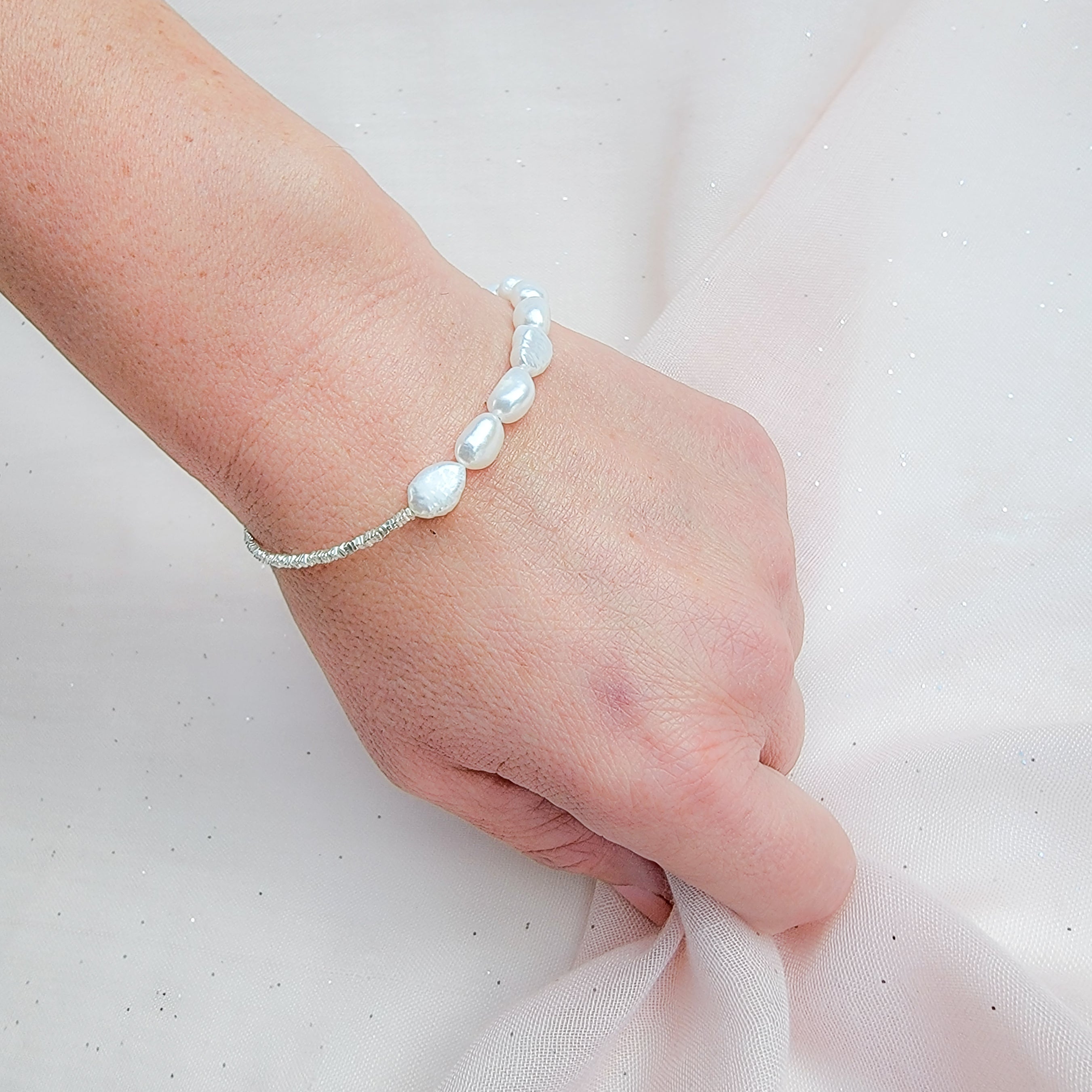 The Pearl-Silver Fusion Bracelet, just like the matching necklace is a stunning blend of romance and style, featuring a unique composition of half baroque pearls and half sterling silver chain. Its design exudes a romantic charm, making it a versatile accessory suitable for various occasions. It can be your elegant bridal necklace, adding a touch of timeless beauty to your wedding attire.