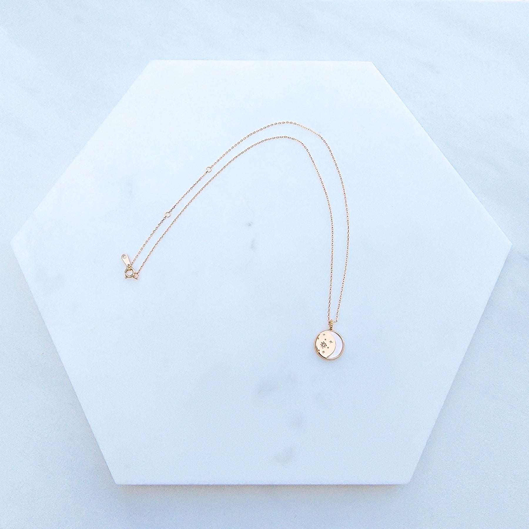 The Moon and Stars Necklace is masterfully crafted in Sterling Silver and plated in Champagne Gold. The pendant featured shell for the outline of the moon representation and cubic zirconia stones to symbolize the stars. What a beautiful piece of jewelry to show appreciation to a love one or celebrate yourself.
