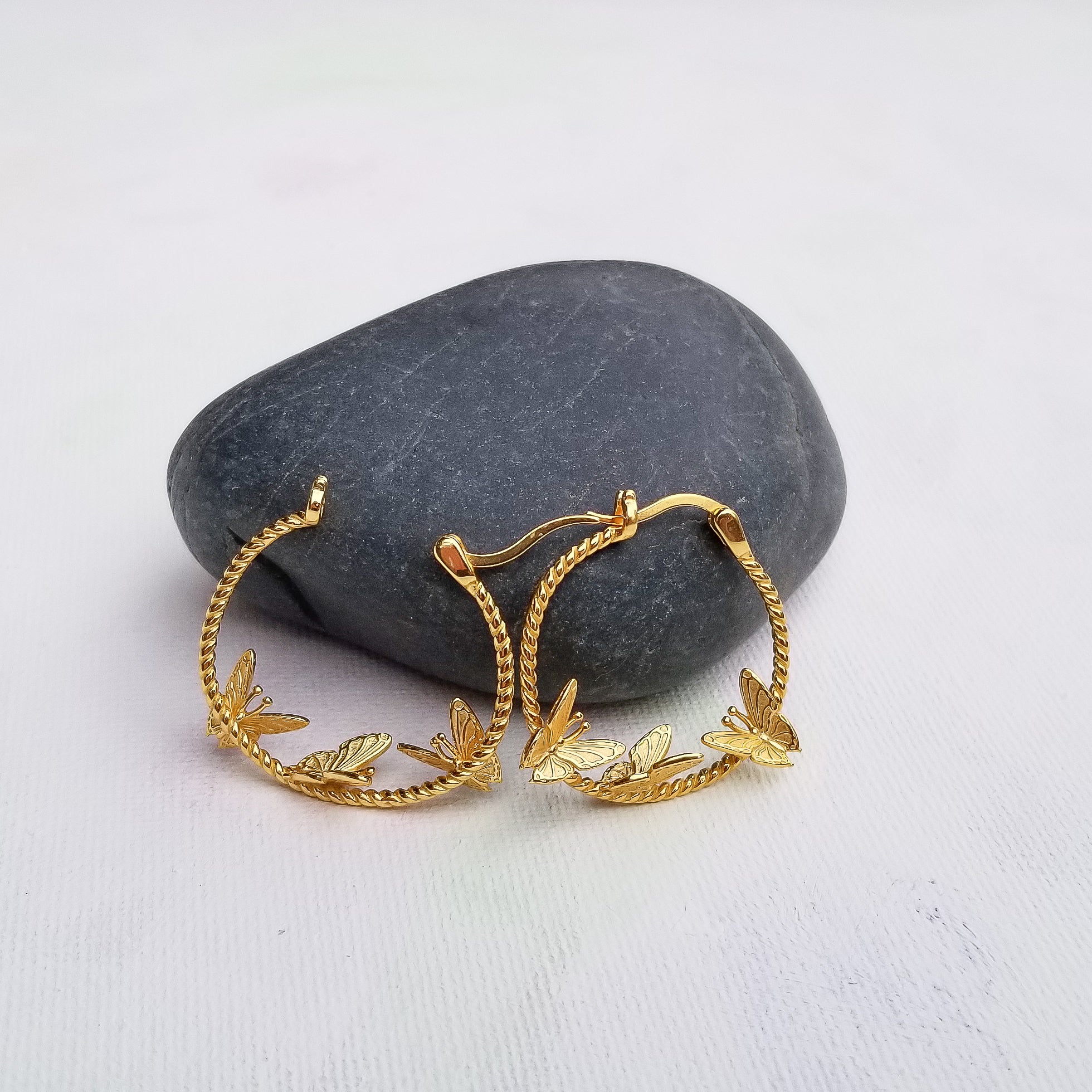 Who does not like butterflies? One of nature's most beautiful creatures is captured perfectly via this delicate pair of butterfly earrings. Crafted beautifully in a flying position, in 14K Gold Plated 925 Sterling Silver, the Flying Butterflies Earrings dangle below the earlobes for a subtle and beautiful look. Material: 14K Gold Plated 925 Sterling Silver Shape: Butterflies on a hoop style Nickel & Lead free & Hypoallergenic Earrings are held in place by Sterling Silver earring backs.