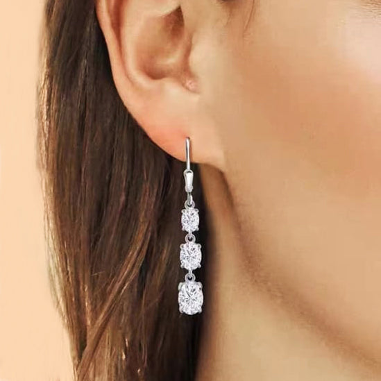 The Astrid Earrings feature 1.2 Carat Moissanite diamonds for each earring, boasting extraordinary beauty. They are crafted in Certified Sterling Silver and plated in 18K White Gold each earring featuring three brilliant Moissanite stones. Exuding sophistication, they are perfect for special occasions and make a great option as Bridal earrings.  Lever backs provide security and comfort all day long.