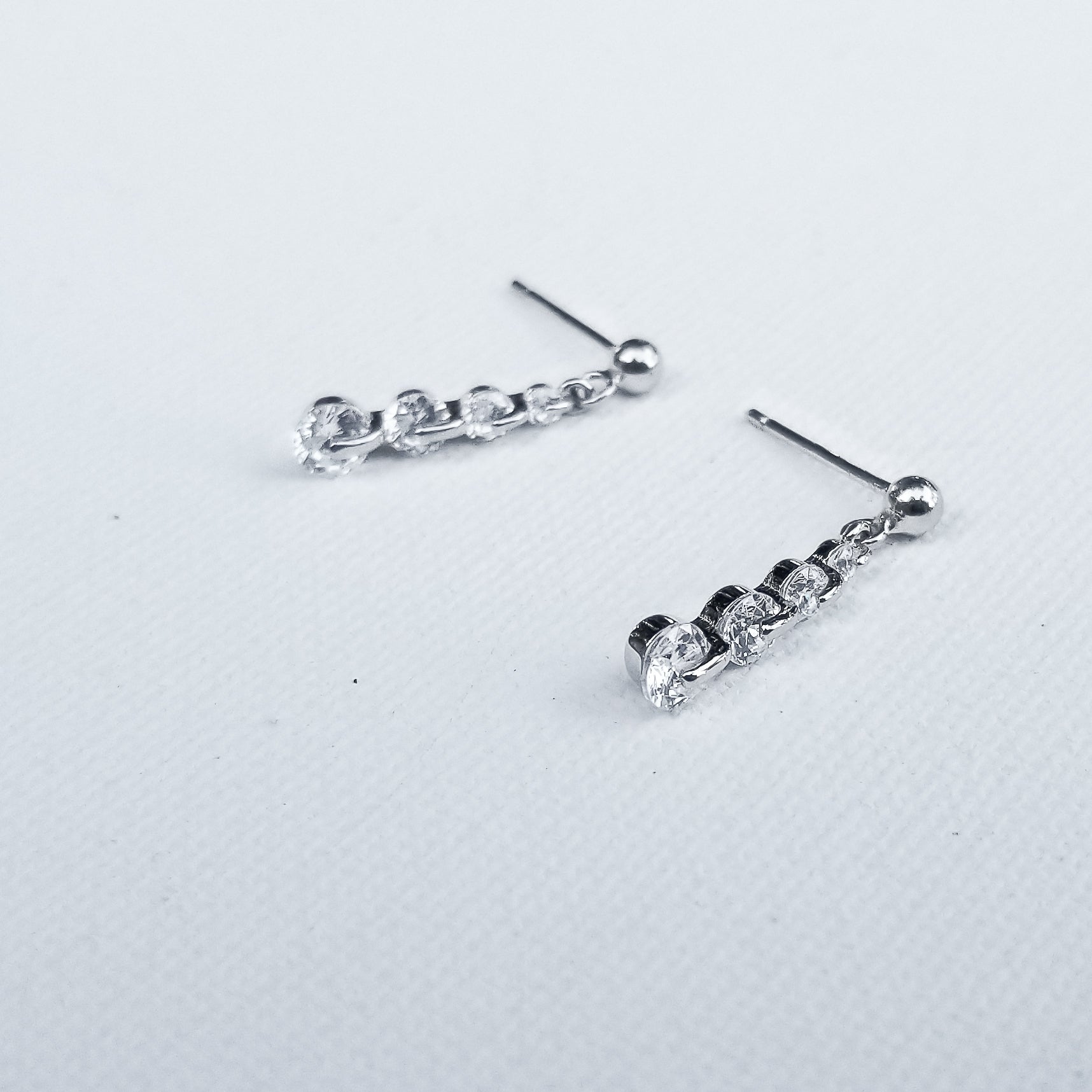 Sparkle your way to the top with the gorgeous Linear Drop Cubic Zirconia Earrings. The chain, crafted in 925 Sterling Silver and plated in White Gold showcasing 5 Cubic Zirconia is the perfect touch of glow  and elegance. Perfect for special occasions or everyday styling to show your amazing confidence and glam.