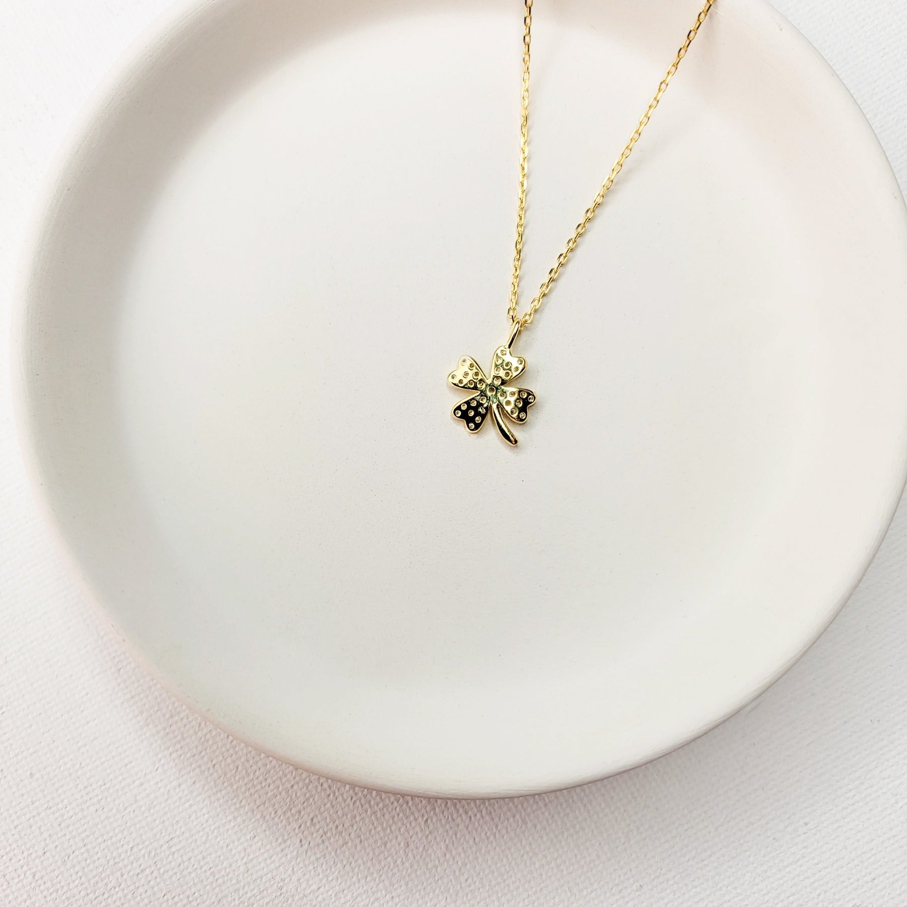 A beautiful design featuring a graceful four-leaf clover handcrafted in Sterling Silver and plated in 14 K Gold, the Lucky Clover and Sparkles Necklace showcases tiny cubic zirconia stones ( pink or white). Recognized as the universal symbol of good luck, this clover pendant necklace can be a wonderful gift for any occasion. Options:      Sterling Silver with14 K White Gold Plating and Pink Zirconia Stones Sterling Silver with 14 K Yellow Gold Plating and White Zirconia Stones