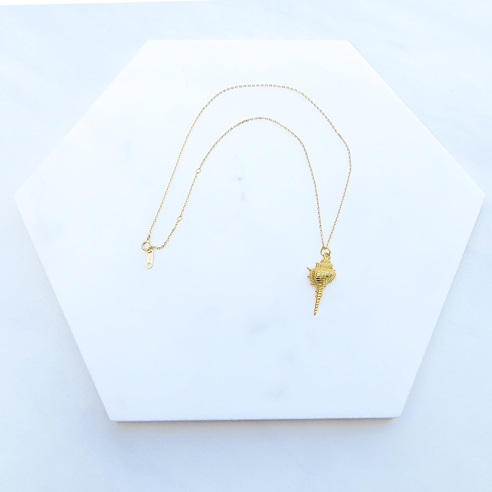 Are you dreaming of the beach? What a stylish way to add some under the sea glamour to your life with this Dazzling Conch Shell Necklace. Featuring a high polished finish for long-lasting shine, the conch shell pendant hangs from a 17-inch chain. Both the pendant and chain are crafted in 925 Sterling Silver and are plated in Gold. Do you prefer white Gold or yellow Gold?  