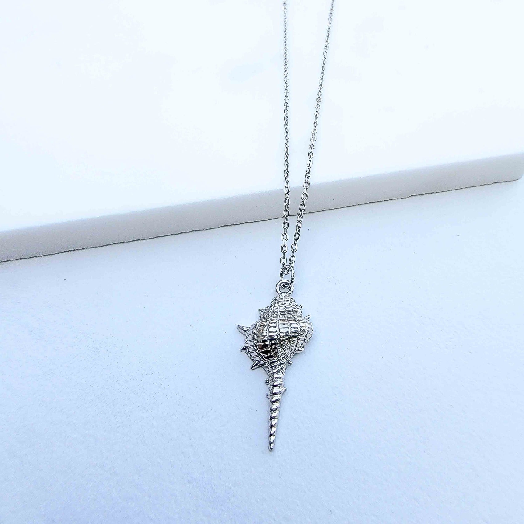 Are you dreaming of the beach? What a stylish way to add some under the sea glamour to your life with this Dazzling Conch Shell Necklace. Featuring a high polished finish for long-lasting shine, the conch shell pendant hangs from a 17-inch chain. Both the pendant and chain are crafted in 925 Sterling Silver and are plated in Gold. Do you prefer white Gold or yellow Gold?  