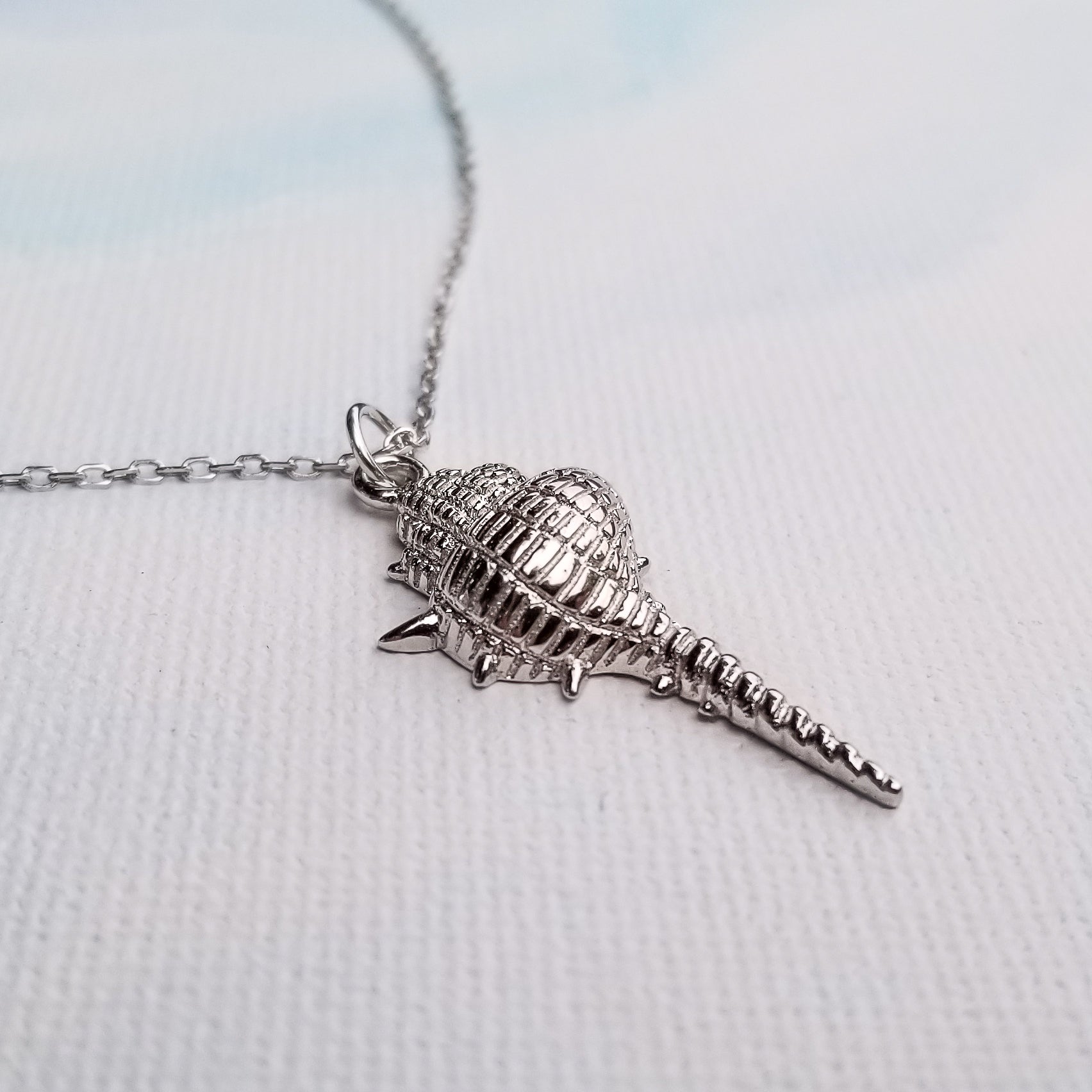 Are you dreaming of the beach? What a stylish way to add some under the sea glamour to your life with this Dazzling Conch Shell Necklace. Featuring a high polished finish for long-lasting shine, the conch shell pendant hangs from a 17-inch chain. Both the pendant and chain are crafted in 925 Sterling Silver and are plated in Gold. Do you prefer white Gold or yellow Gold?  